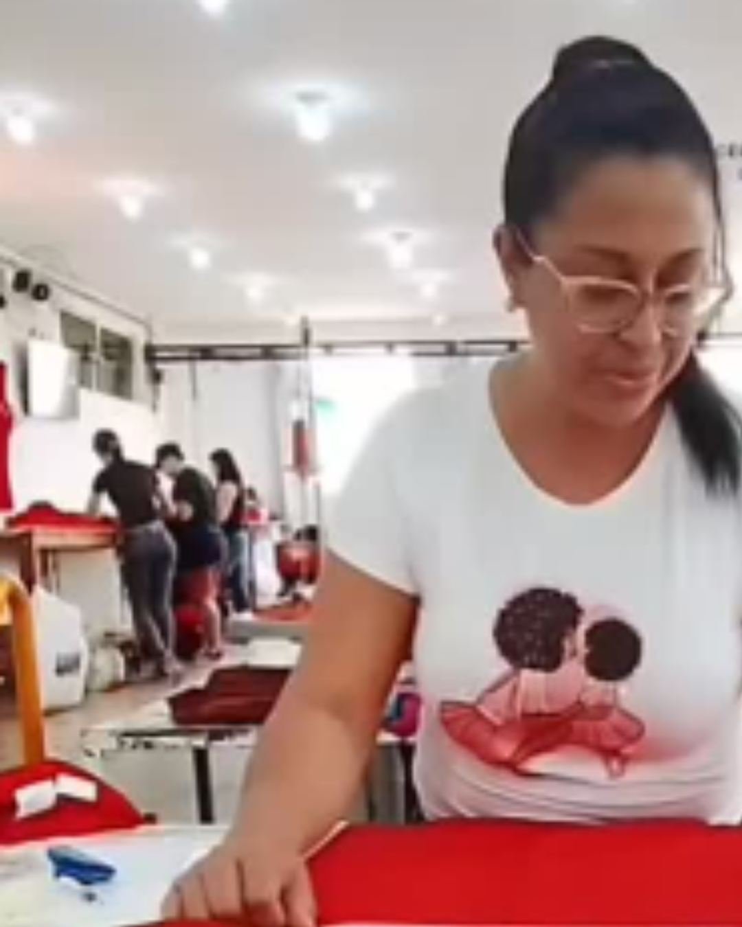 Colaboradora da produção com peça de camiseta estampada